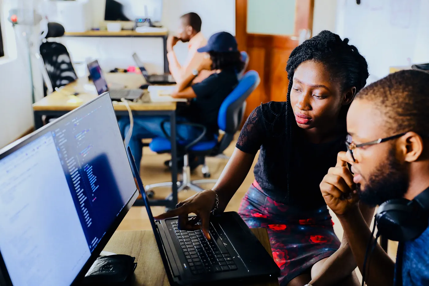 Two people look at a computer screen